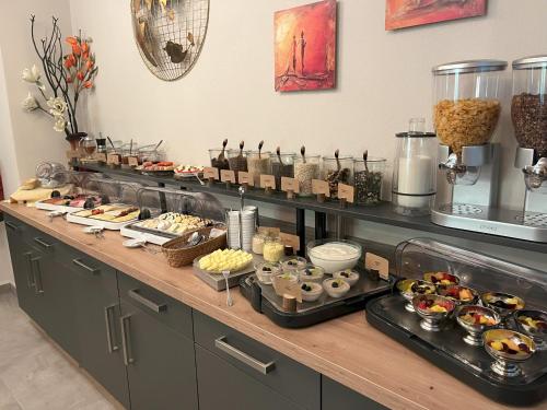 バート・ズダーオーデにあるLe petit Palais - Hotel/Pensionのカウンターにさまざまな種類の食べ物が並んだビュッフェ