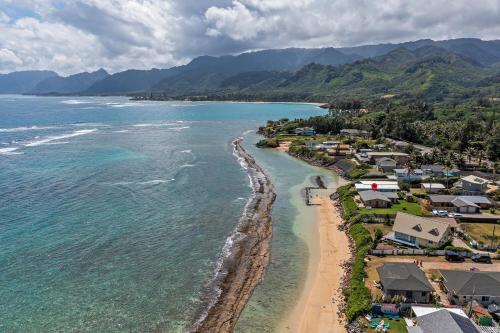 eine Luftblick auf einen Strand mit Häusern und das Meer in der Unterkunft Oahu's Best Kept Secret in Laie