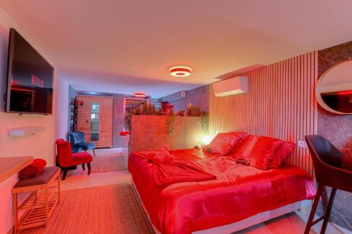 een slaapkamer met een rood bed en een tafel en stoelen bij Expérience des sens in Grézieu-la-Varenne