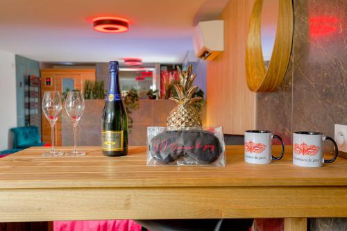 a table with a bottle of wine and two glasses at Expérience des sens in Grézieu-la-Varenne