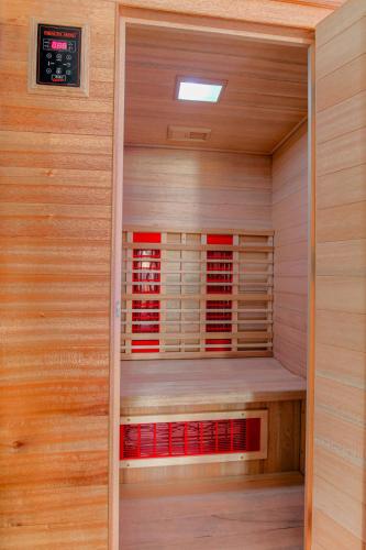 a sauna with wood paneling and red accents at Expérience des sens in Grézieu-la-Varenne