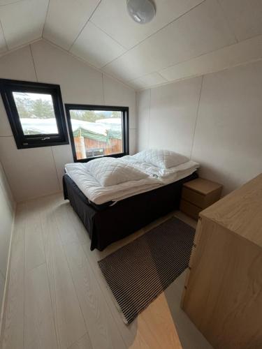 una piccola camera da letto con un letto e una finestra di Hyt leilighet med 2 soverom a Bjorli