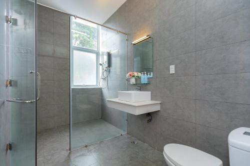 ein Badezimmer mit Dusche, Waschbecken und Toilette in der Unterkunft Palm Villa 20 - Style Tropical 7bedrooms, bida, karaoke in Vũng Tàu