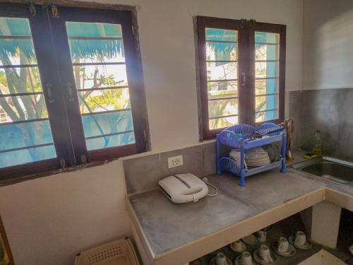 una cucina con un lavello e due finestre di Villa NOAH BEACH ZANZIBAR a Kiwengwa