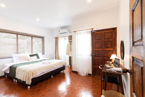 une chambre avec un lit et une fenêtre dans l'établissement Merry House Chiang Mai, à Chiang Mai