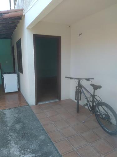 a bike parked next to a building with a garage at Casa da Flávia in Búzios