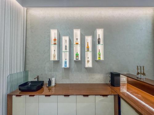 een badkamer met een wastafel en enkele flessen aan de muur bij Luxe Apartment in Hyderabad