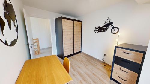 a room with a table and a motorcycle on the wall at Le Duplex Forêt Noire in Illkirch-Graffenstaden