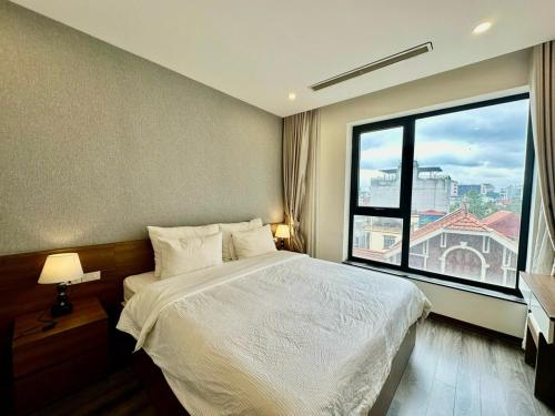 Un dormitorio con una cama y una ventana grande. en BEU Home Tay Ho, en Hanói