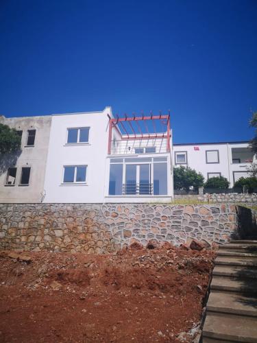 a white building with a stone retaining wall at reklo in Altındağ