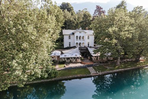 an aerial view of a white house with trees and water at Penzion Vila Prešeren in Bled