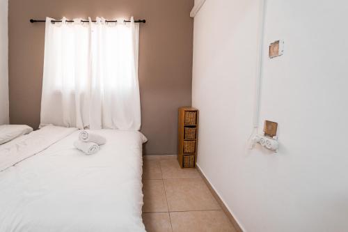 ein kleines Schlafzimmer mit einem Bett und einem Fenster in der Unterkunft Mellow Bay in Eilat