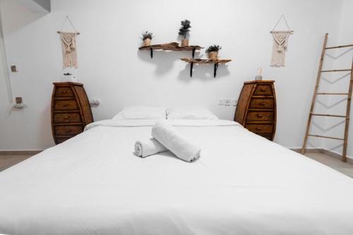 1 Schlafzimmer mit 2 Betten mit weißer Bettwäsche und Holzmöbeln in der Unterkunft Mellow Bay in Eilat