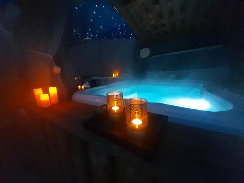 uma banheira de hidromassagem com velas ao lado de um quarto em L'antre deux Pierres, suite de charme, romantisme, jacuzzi privé, braséro em Bouyon
