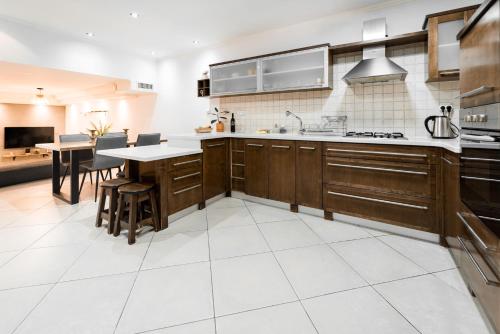 a kitchen with wooden cabinets and a white tile floor at Mellow Bay in Eilat