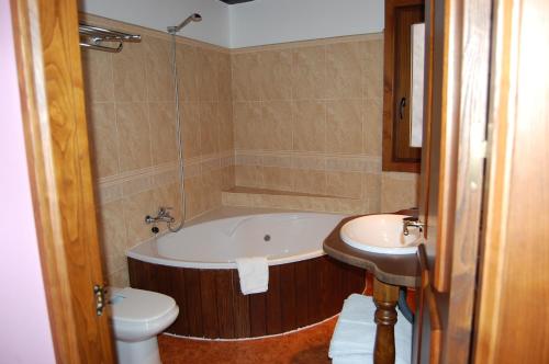 a bathroom with a tub and a toilet and a sink at Pacio do Sil in La Rúa