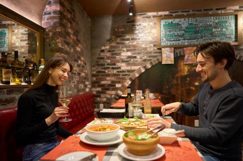 a man and woman sitting at a table in a restaurant at Hotel Resol Kyoto Shijo Muromachi in Kyoto