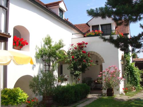 una casa blanca con flores en un patio en Gästehaus Hans Moser en Purbach am Neusiedlersee
