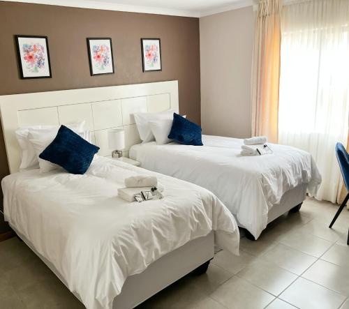 2 Betten in einem Hotelzimmer mit Handtüchern darauf in der Unterkunft Mapalesa Guest House in Mohales Hoek