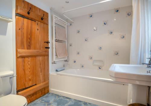 La salle de bains est pourvue d'une baignoire, d'un lavabo et de toilettes. dans l'établissement Clare Cottage, à Melton Constable