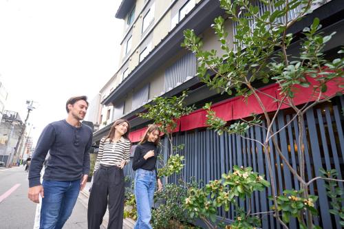 a group of three people walking down a street at Hotel Resol Kyoto Shijo Muromachi in Kyoto