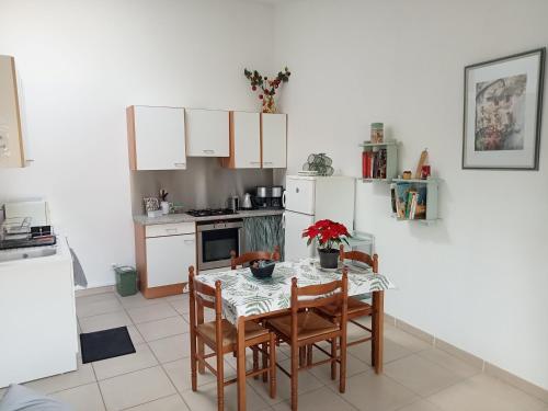 a kitchen with a table and chairs and white cabinets at Gîte du Portail Vert in Codognan