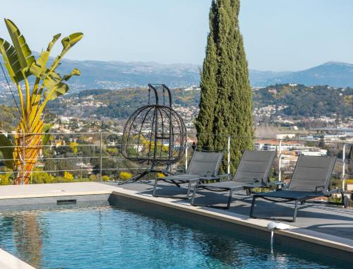 un groupe de chaises assises à côté d'une piscine dans l'établissement Superbe Villa vue Mer Époustouflante proche Cannes, à Mandelieu-la-Napoule