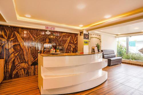 a lobby with a bar in front of a wall at FabHotel Ambika Elite in Vijayawāda