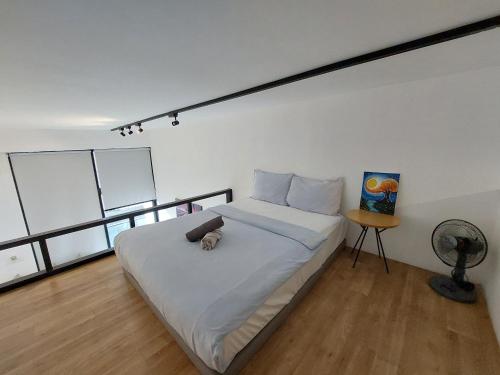 una camera da letto con un grande letto bianco e un ventilatore di KL Sentral Loft, EST Bangsar #3, LRT a Kuala Lumpur