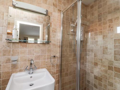 uma casa de banho com um lavatório e um chuveiro em Beachside Beadnell em Beadnell