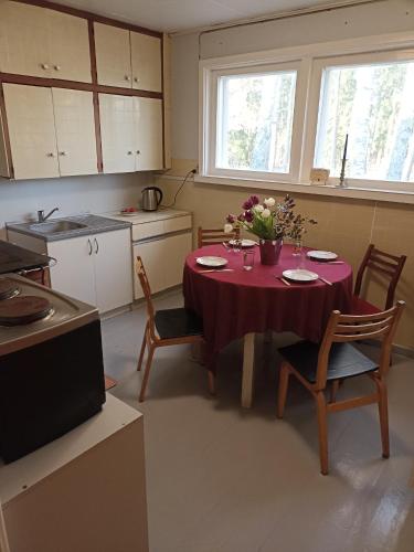 a kitchen with a table with a red table cloth at Kollane Maja in Leisi
