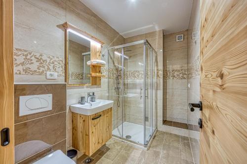 een badkamer met een douche, een wastafel en een toilet bij Apartments Viktor in Rateče