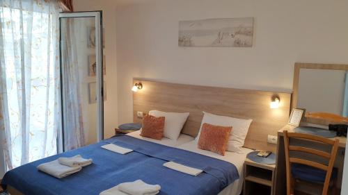 a bedroom with a large bed with a blue blanket at Guesthouse Tri Palme in Becici