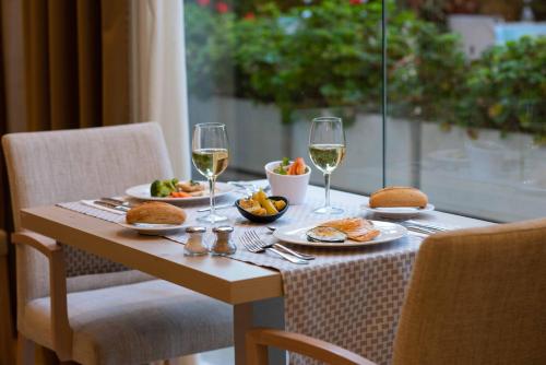 a table with two glasses of wine and food on it at Valentin Somni Hotel & Suites in Paguera