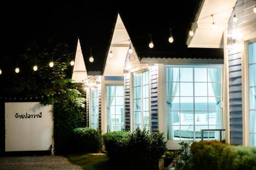 ein Gebäude mit Fenstern mit Licht und Pflanzen in der Unterkunft Baan Plawan Resort Chiang Rai in Chiang Rai