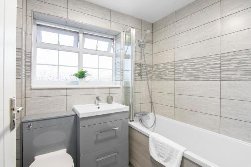a bathroom with a toilet and a sink and a tub at Gravesend 3 Beds By JADA Homes in Kent