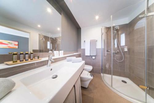 a bathroom with a sink and a shower and a toilet at OCEANO Health Spa Hotel in Punta del Hidalgo