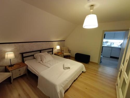 ペルトシャッハ・アム・ヴェルターゼーにあるAm Hügel Apartmentのベッドルーム(大きな白いベッド1台、ランプ付)