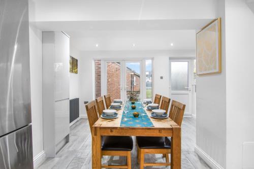 a dining room with a wooden table and chairs at Gravesend 3 Beds By JADA Homes in Gravesend