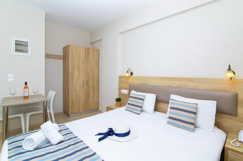 a bedroom with a bed with a blue and white striped blanket at Theo Star Beach Hotel in Malia