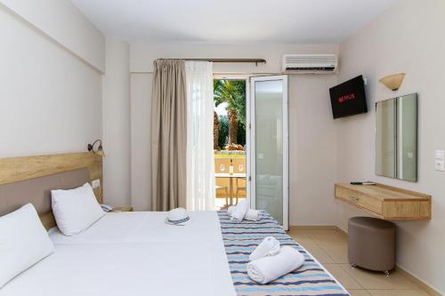 a hotel room with a bed and a balcony at Theo Star Beach Hotel in Malia