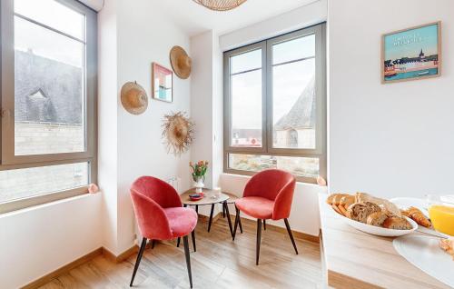 a kitchen with red chairs and a table and windows at 1 Bedroom Stunning Apartment In Melrand in Melrand