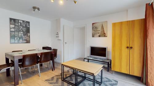 un salon avec une table à manger et une télévision dans l'établissement Les appartements de Georges avec parking, à Colmar