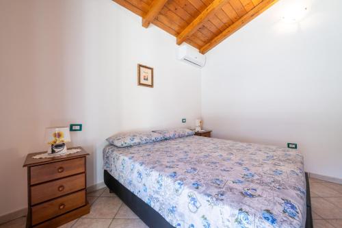 a bedroom with a bed and a wooden ceiling at Casa Vacanza Ghisu in SantʼAnna Arresi