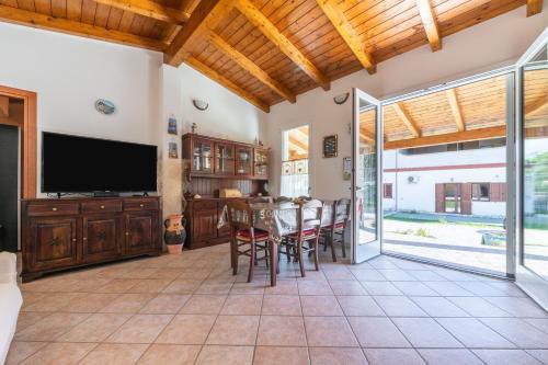 a living room with a table and chairs and a television at Casa Vacanza Ghisu in SantʼAnna Arresi
