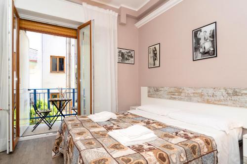 a bedroom with two beds and a large window at Ostello Le Sirene in Sorrento
