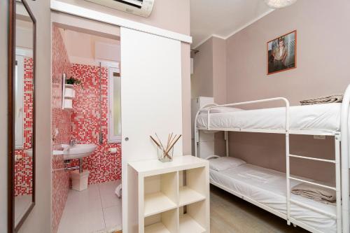 ein kleines Zimmer mit einem Etagenbett und einem Badezimmer. in der Unterkunft Ostello Le Sirene in Sorrent