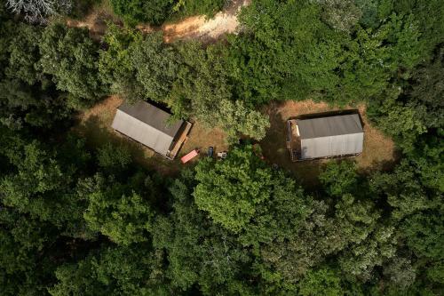 Vue de deux bâtiments de la forêt dans l'établissement Glamping Les Eyzies, à Carmensac