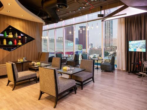 Un restaurante con mesas y sillas y vista a la ciudad. en VELA Dhi GLOW Pratunam, en Bangkok