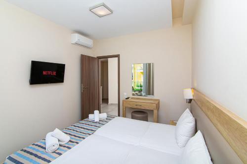a bedroom with a white bed and a desk at Theo Star Beach Hotel in Malia
